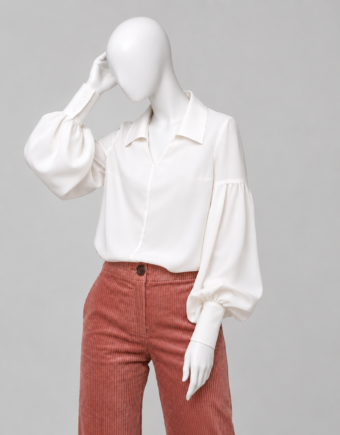 Voluminous blouse of A-silhouette hits below the hip line. G