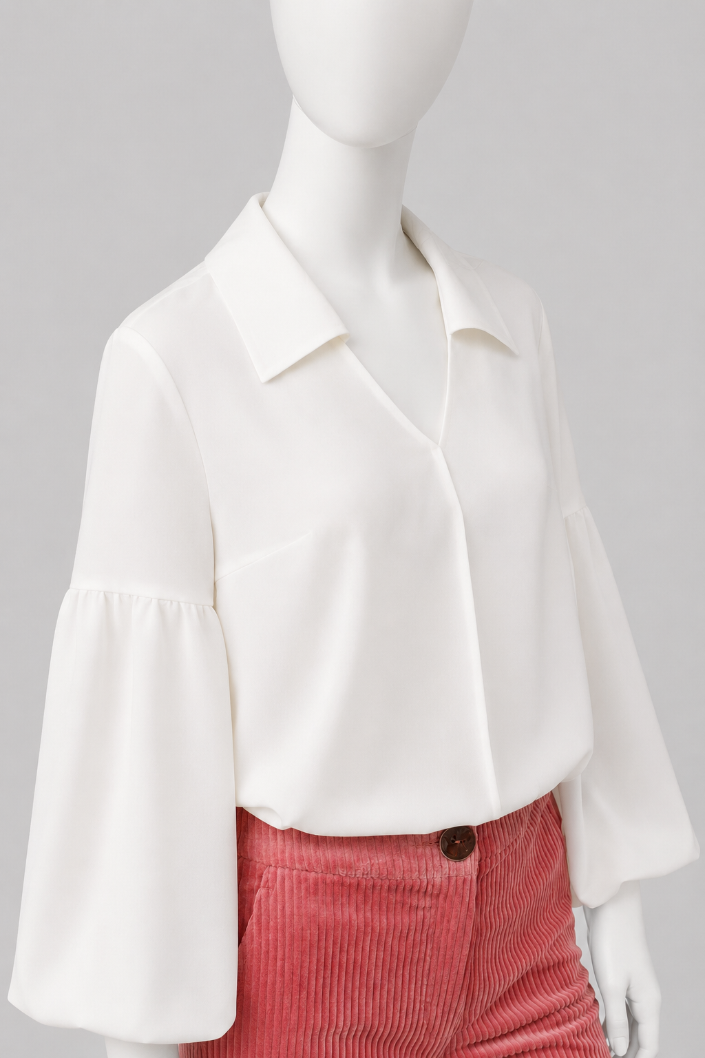 Voluminous blouse of A-silhouette hits below the hip line. G