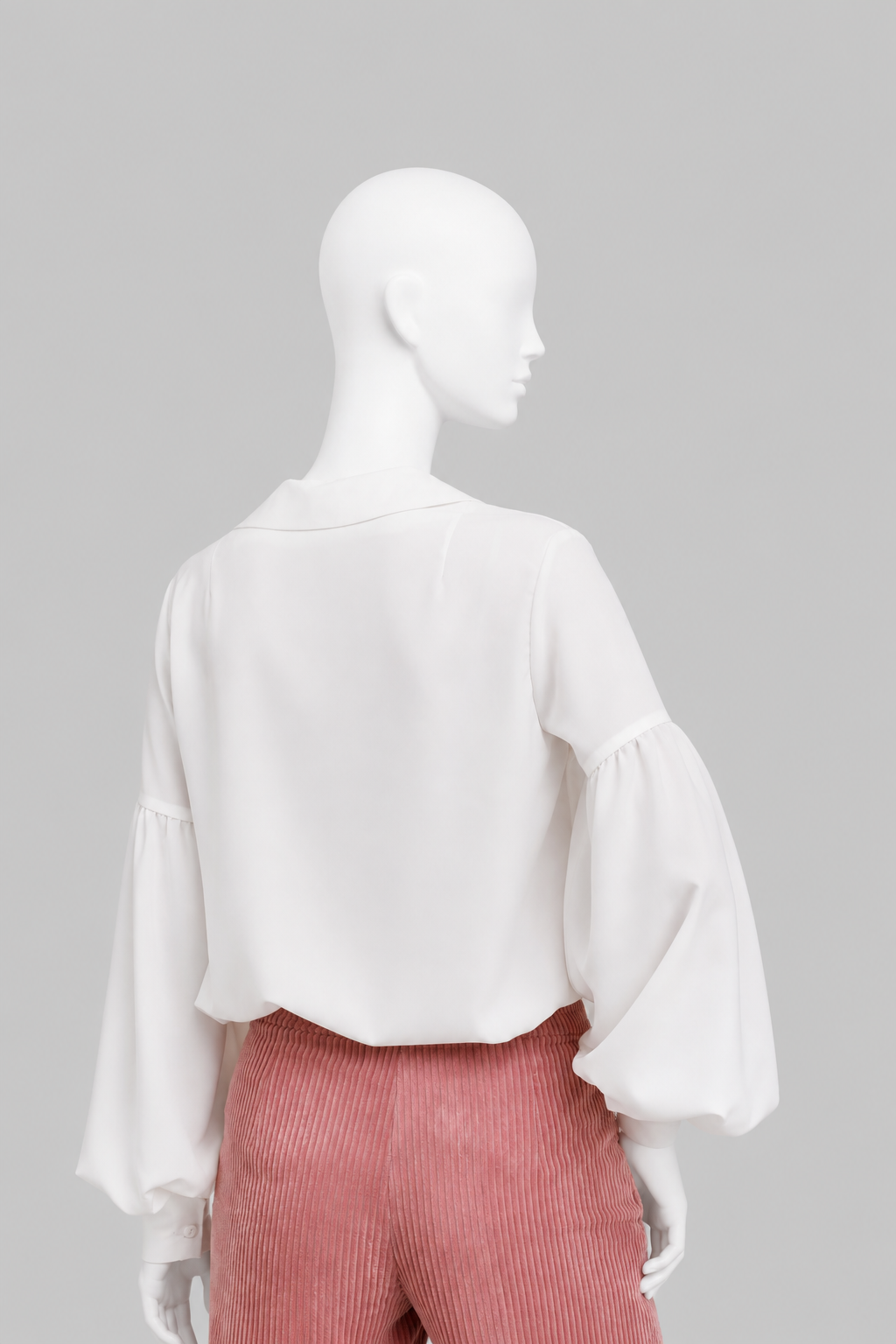 Voluminous blouse of A-silhouette hits below the hip line. G